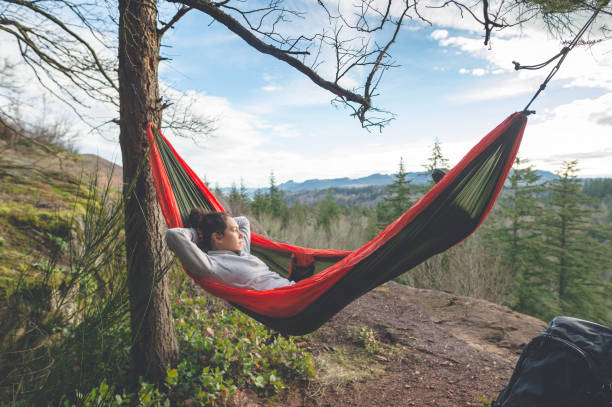 istock Young woman in hammock in forest 679673084