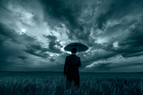 istock Man in black suit with a black umbrella in a storm 679694154