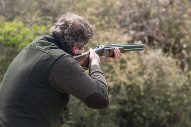 cazador en el bosque durante la temporada de caza apuntando antes de disparar - rifle shotgun hunting camouflage fotografías e imágenes de stock