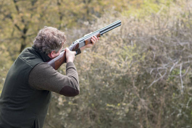 cazador en el bosque durante la temporada de caza apuntando antes de disparar - rifle shotgun hunting camouflage fotografías e imágenes de stock