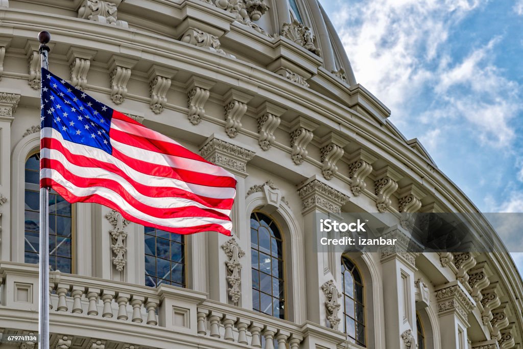 Washington DC Capitol view on cloudy sky Washington DC Capitol dome detail with waving american flag USA Stock Photo