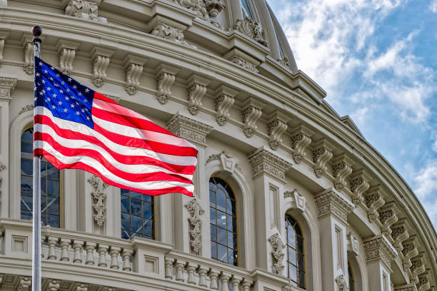 Washington DC Capitol view on cloudy sky Washington DC Capitol dome detail with waving american flag united states congress photos stock pictures, royalty-free photos & images