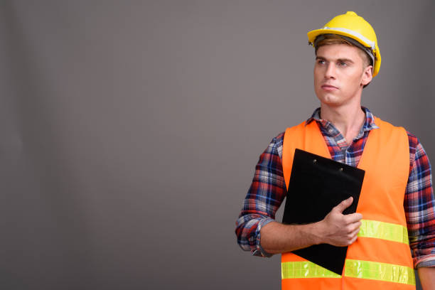 istock Studio shot of young muscular handsome man construction worker against gray background 679741368