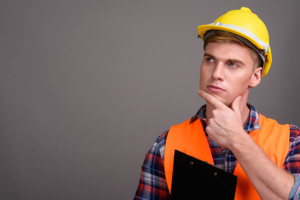 istock Studio shot of young muscular handsome man construction worker against gray background 679741370