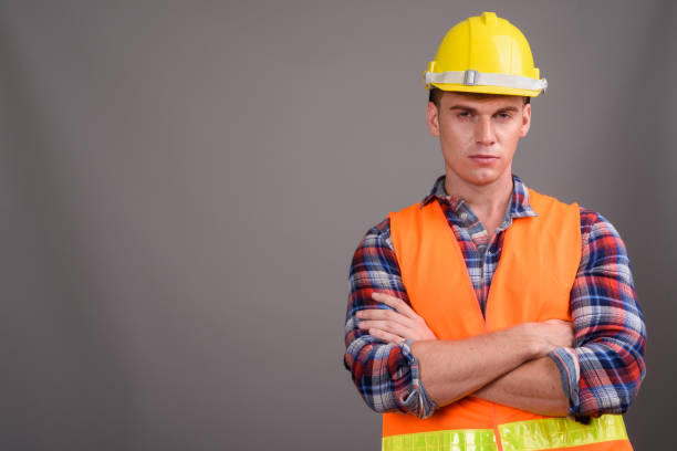 istock Studio shot of young muscular handsome man construction worker against gray background 679741382