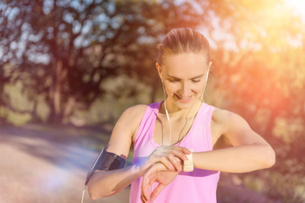 runner che controlla la sua performance sull'orologio - pulse clock foto e immagini stock