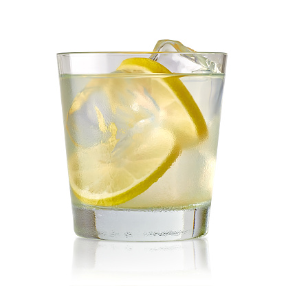 Gin tonic or vodka with lemon slices on white background