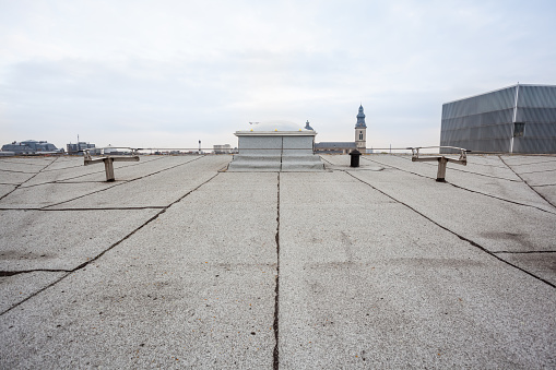 On a tall building in the city there is a large roof terrace white dome