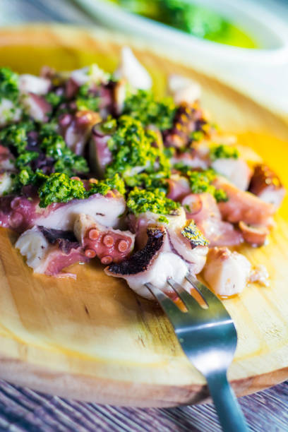 istock Octopus with paprika and sauce on a wooden table 679782136