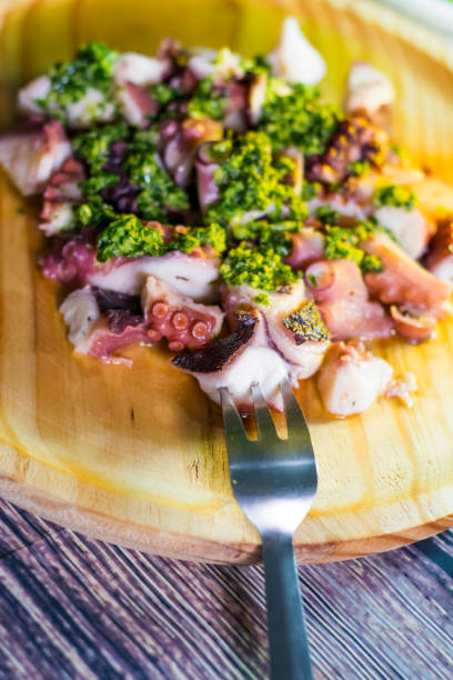 istock Octopus with paprika and sauce on a wooden table 679793304