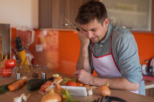 istock Handsome single attractive man finding recipes and making food 679797470