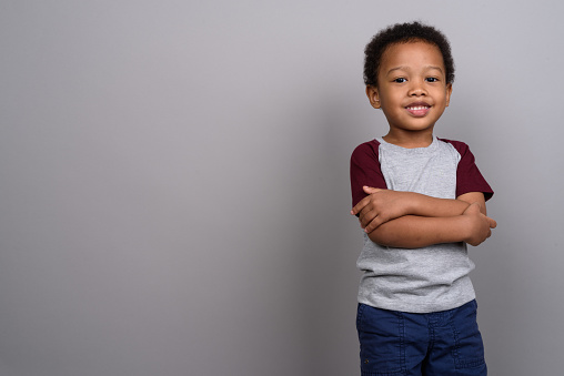 Studio shot of young African boy against gray background