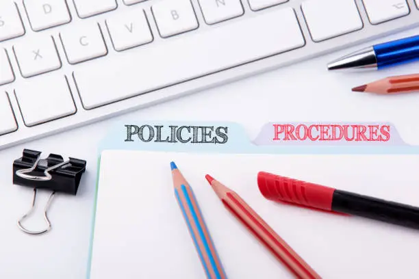 Photo of Policies and Procedures. Folder Register on a white Office Table