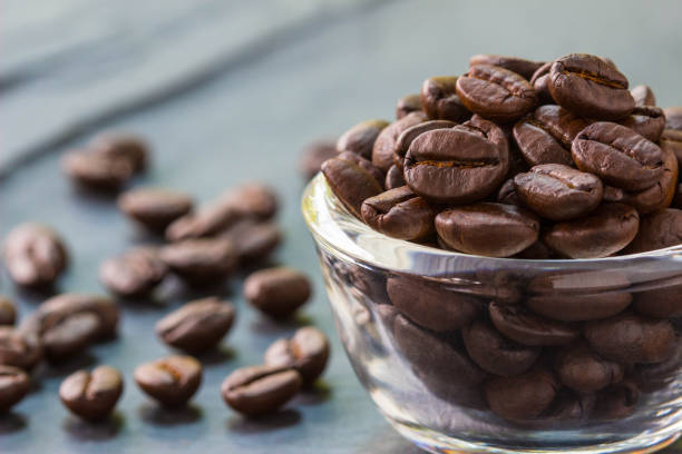 istock Coffee beans in clear glass cup  on stone plate , selective focus 679821026