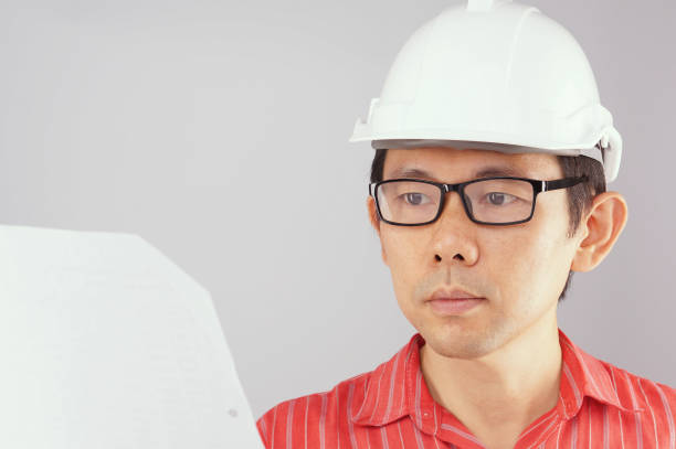istock Engineer wear red shirt is looking at document white background 679821224