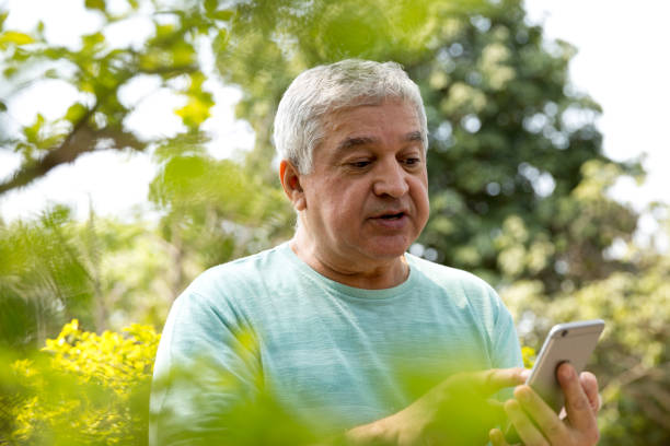 istock Senior man typing message in the park 679829248
