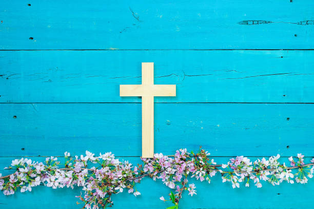 istock Wood cross hanging over spring flowers 679829390
