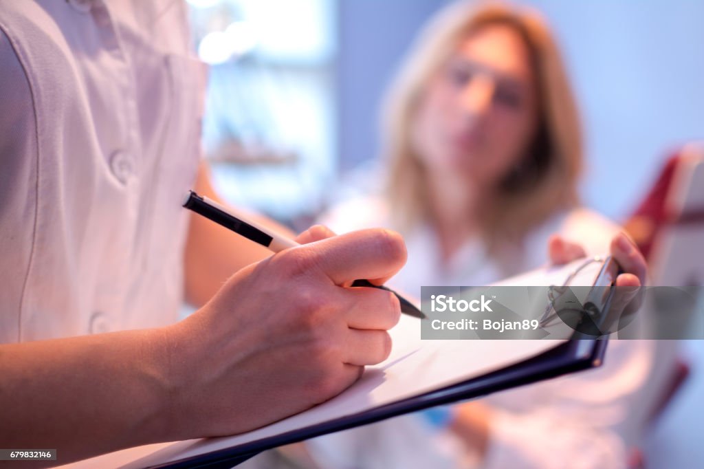 Fermez-vous vers le haut de l’écriture de médecin sur une carte médicale. - Photo de Recherche médicale libre de droits