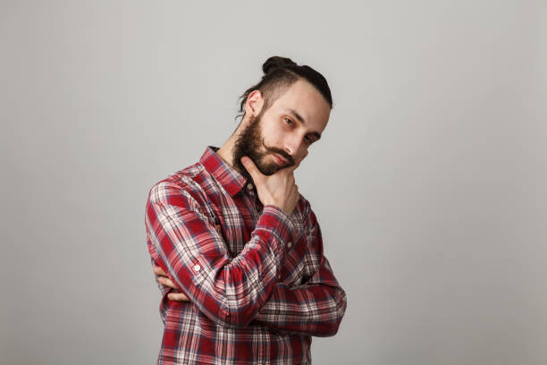 istock Bearded handsome man is thinking in red squared shirt on grey background 679839694