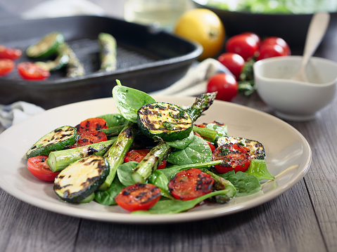 Grilled asparagus,courgette and cherry tomatoes with baby spinach salad,service with basil mustard olive oil dressing