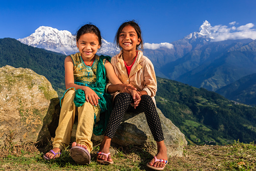 Happy Nepali little girls, Annapurna Range on background. The Annapurna region is in western Nepal where some of the most popular treks (Annapurna Sanctuary Trek, Annapurna Circuit) are located. Peaks in the Annapurnas include 8,091m Annapurna I, Nilgiri and Machhapuchchhre. The Annapurna peaks are among the world's most dangerous mountains to climb.