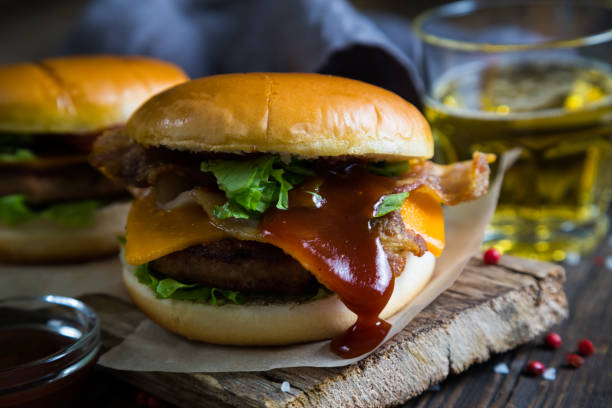 istock Hamburgers and beer on a wooden table 679868014