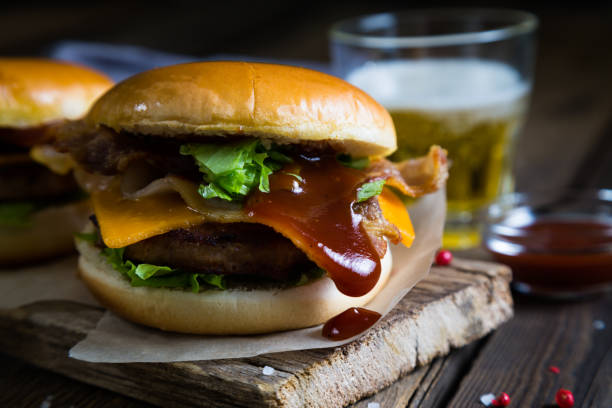 istock Hamburgers and beer on a wooden table 679868260