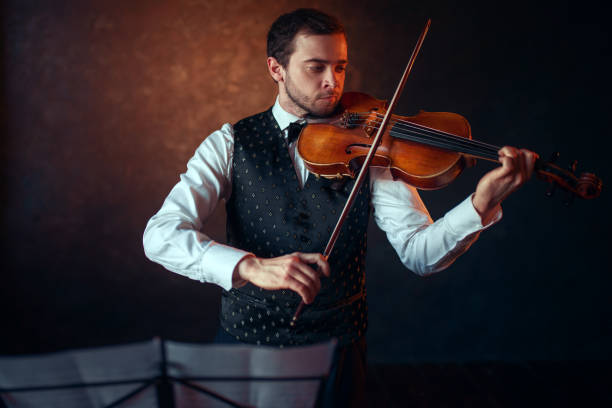 istock Male violinist playing classical music on violin 679869144