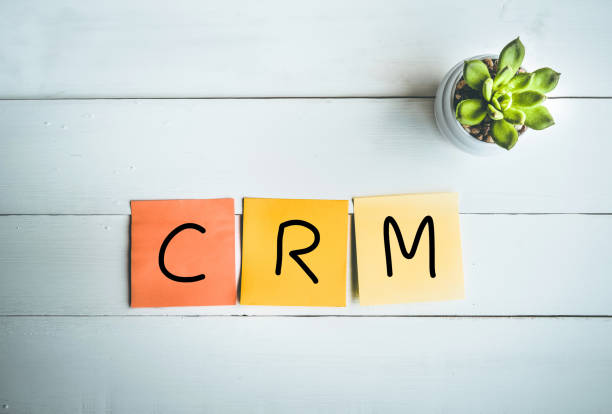 白い木製テーブル背景に紙ノートと crm 単語 - plan c ストックフォトと画像