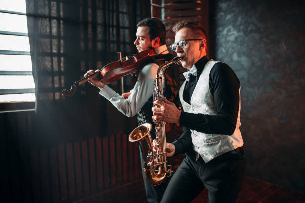 istock Sax man and fiddler duet playing classical melody 679870062