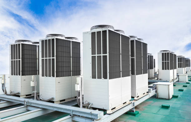 fila de unidades de aire acondicionado en azotea con cielo azul - central unit fotografías e imágenes de stock