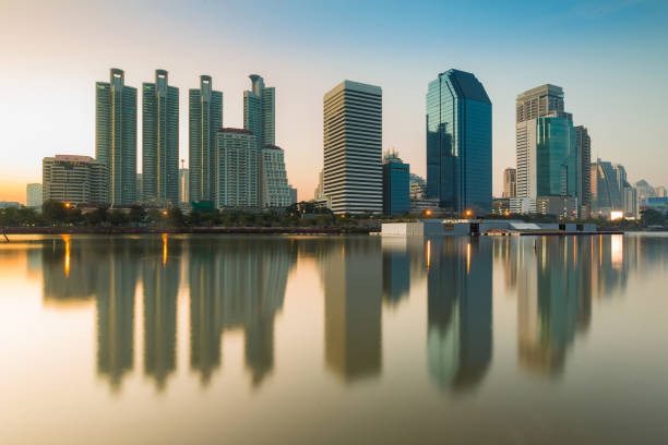 istock Sunrise tone over office building with water reflection in public park 679882118