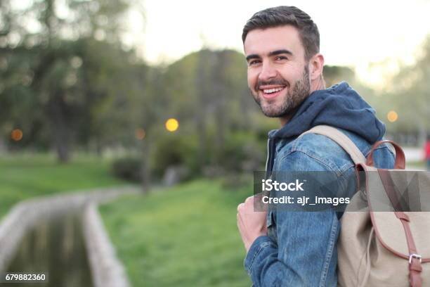 Smiley Male Holding Backpack Outdoors With Copyspace Stock Photo - Download Image Now