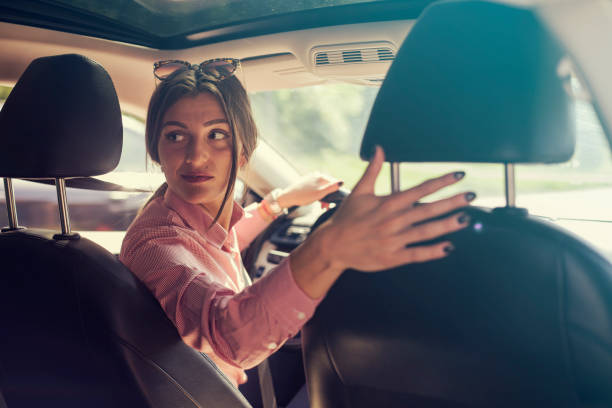 mujer mirando hacia atrás mientras la inversión - aparcar fotografías e imágenes de stock