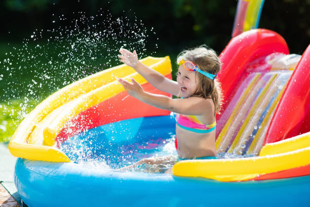 istock Child in garden swimming pool with slide 679897012