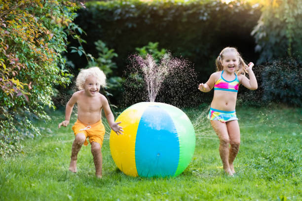 niños jugando con rociador de juguete de bola de agua - 12018 fotografías e imágenes de stock