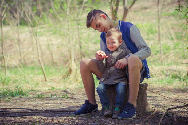 istock Two cute kids sitting on log in forest. 679910922