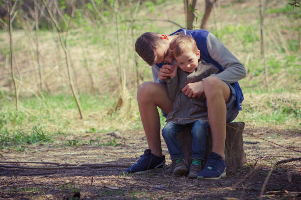 istock Two cute kids sitting on log in forest. 679910954