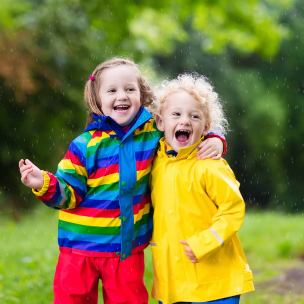 istock Kids play in rain and puddle in autumn 679915002