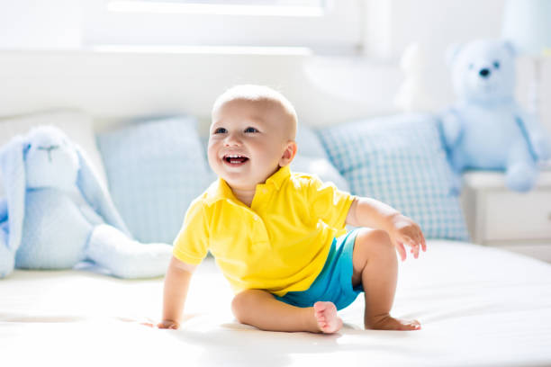 istock Baby boy playing on bed in sunny nursery 679915758