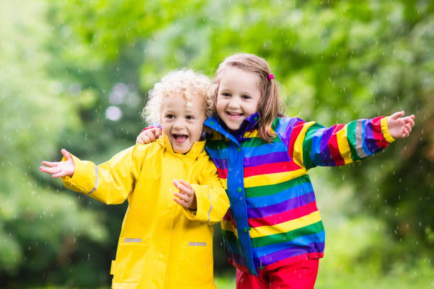 istock Kids play in rain and puddle in autumn 679916856