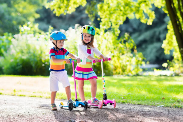 istock Kids riding scooter in summer park. 679916904