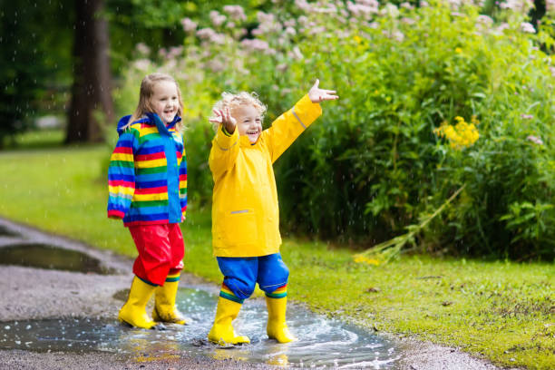 istock Kids play in rain and puddle in autumn 679917164