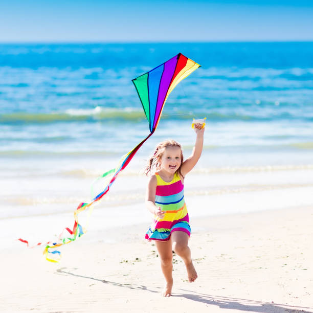 istock Child flying kite on tropical beach 679917490
