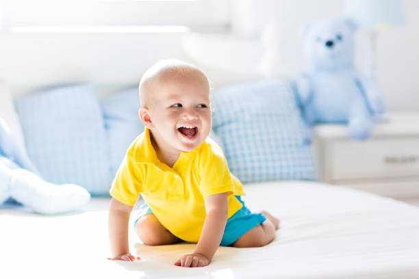 istock Baby boy playing on bed in sunny nursery 679919406