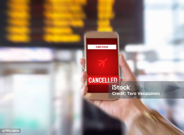 Flight Cancelled Smartphone Application Announces Bad News To Tourist Strike Or Problem With Plane Woman Holding Mobile Phone In Airport Terminal Timetable And Schedule In The Blurred Background Stock Photo - Download Image Now