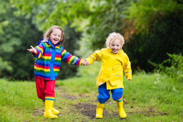 istock Kids play in rain and puddle in autumn 679924032