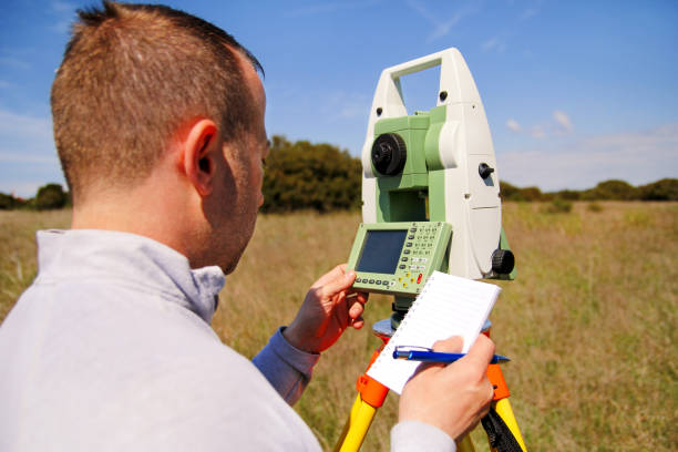 Man using of total station. Guy surveyor at work. Survey Instrument geodetic device, total station set and surveyor worker making measurement in the field. Total station outdoor at construction site. el hombre uso de estación total. topógrafo de chico en el trabajo. encuesta instrumento geodésico dispositivo, estación total set y topógrafo trabajador hacer la medición en el campo. total de la estación al aire libre en el sitio de construcción.