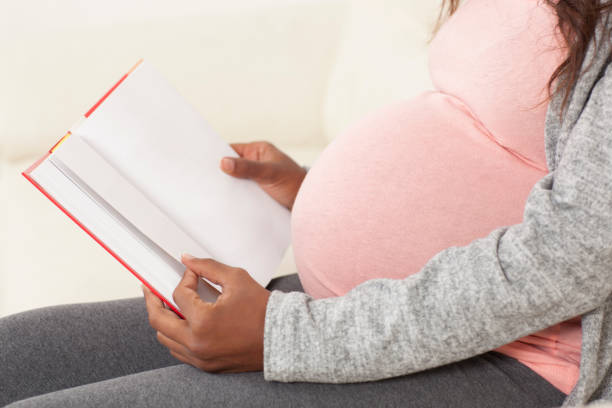 Pregnant woman relaxing reading a book.