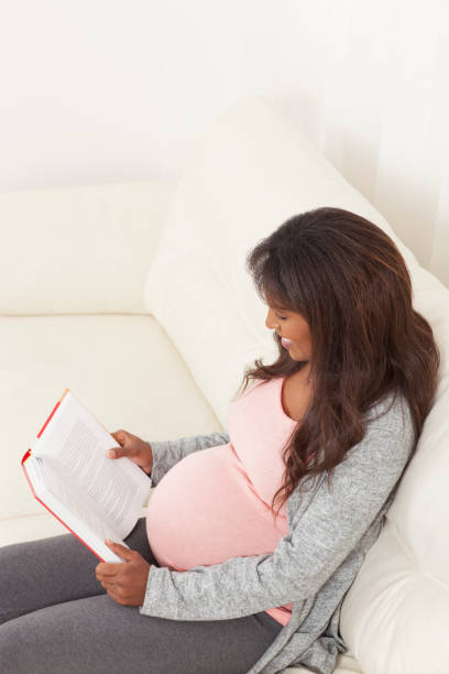 istock Woman resting at home and reading book on sofa. 679939142
